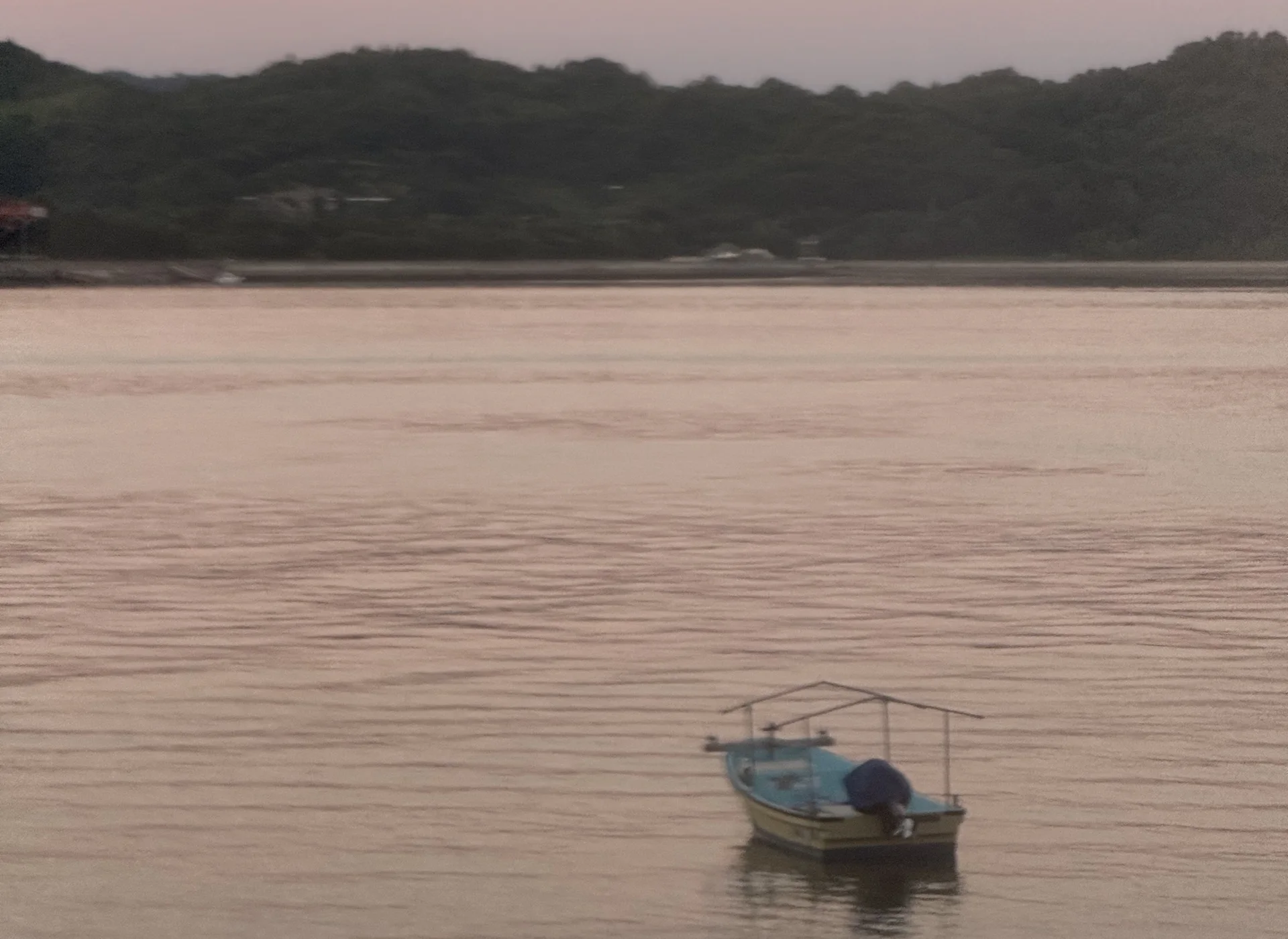 夕暮れの瀬戸内海を進む小さな船